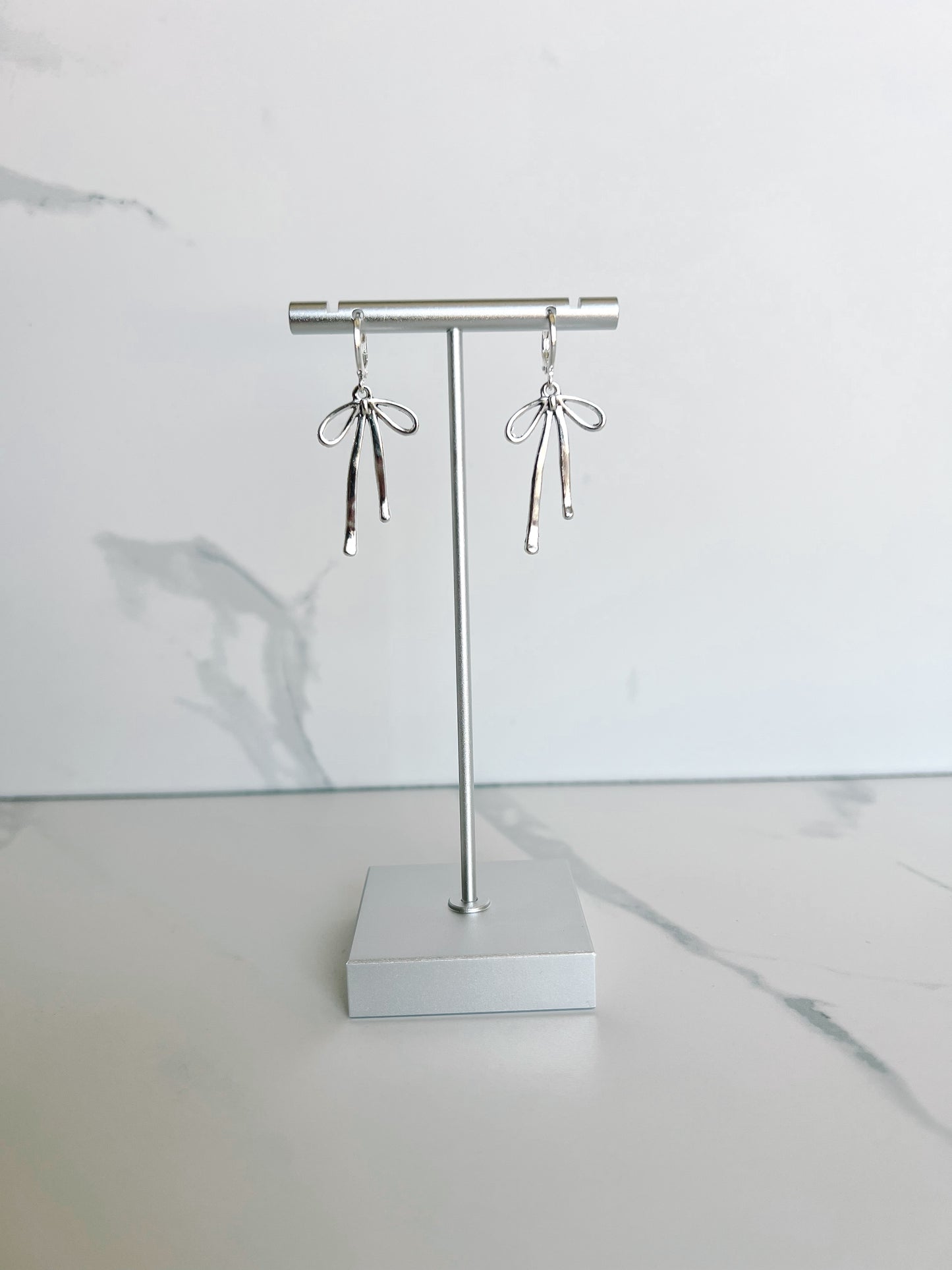 Metal Bow Huggies - Silver